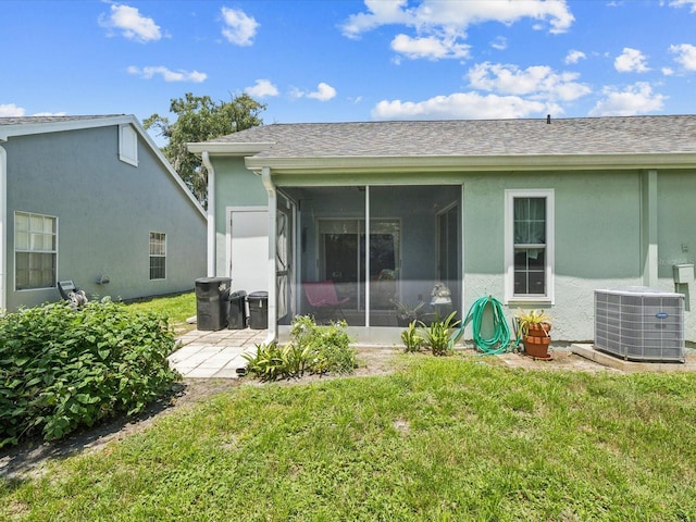 4220 Revere Cir, New Port Richey, FL 34653 - back of property featuring a sunroom, a yard, a shingled roof, and stucco siding