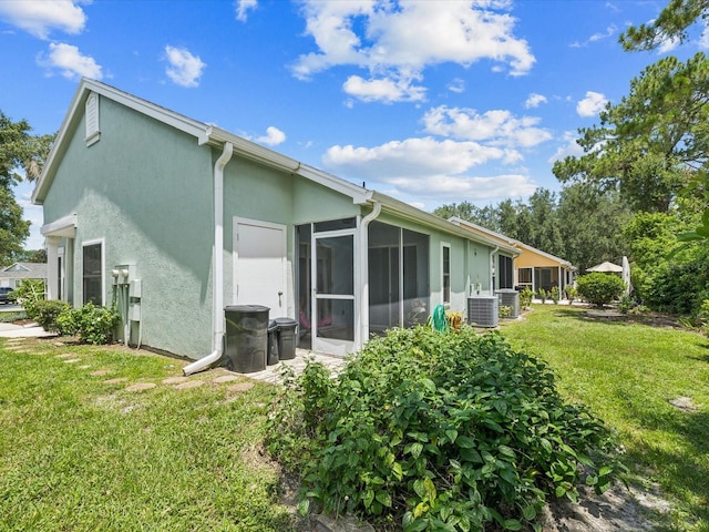4220 Revere Cir, New Port Richey, FL 34653 - rear view of property featuring stucco siding, a sunroom, and a lawn
