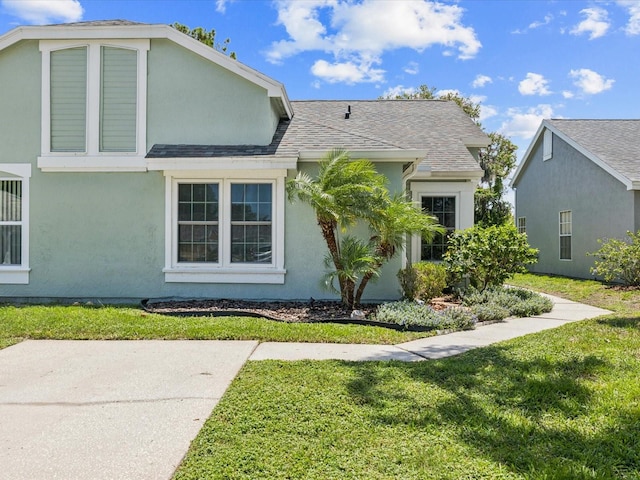 4220 Revere Cir, New Port Richey, FL 34653 - view of front facade featuring stucco siding, a front yard, and roof with shingles