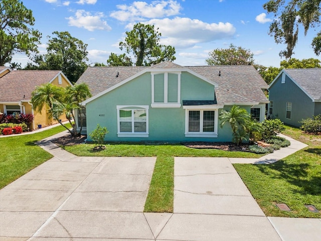 4220 Revere Cir, New Port Richey, FL 34653 - view of front facade featuring stucco siding, a front yard, and a shingled roof