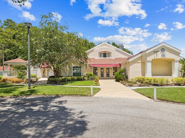 4220 Revere Cir, New Port Richey, FL 34653 - mediterranean / spanish-style home featuring french doors, stucco siding, and a front lawn