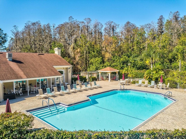 4220 Revere Cir, New Port Richey, FL 34653 - community pool featuring a patio area and view of wooded area