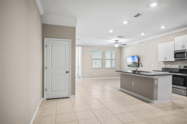 31945 Blue Passing Loop, Wesley Chapel, FL 33545 - kitchen featuring appliances with stainless steel finishes, dark countertops, crown molding, ceiling fan, and a kitchen island with sink