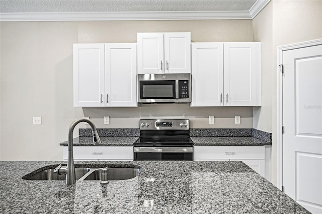 31945 Blue Passing Loop, Wesley Chapel, FL 33545 - kitchen featuring stainless steel appliances, white cabinets, ornamental molding, and dark stone counters