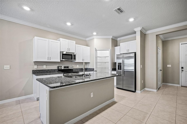 31945 Blue Passing Loop, Wesley Chapel, FL 33545 - kitchen featuring appliances with stainless steel finishes, dark stone counters, white cabinetry, a center island with sink, and ornamental molding