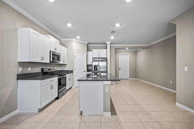 31945 Blue Passing Loop, Wesley Chapel, FL 33545 - kitchen featuring appliances with stainless steel finishes, dark stone counters, white cabinetry, recessed lighting, and a kitchen island with sink