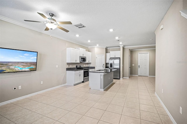31945 Blue Passing Loop, Wesley Chapel, FL 33545 - kitchen featuring appliances with stainless steel finishes, dark countertops, crown molding, white cabinets, and a kitchen island with sink