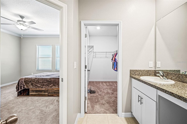 31945 Blue Passing Loop, Wesley Chapel, FL 33545 - bathroom with vanity, a spacious closet, a ceiling fan, crown molding, and tile patterned floors