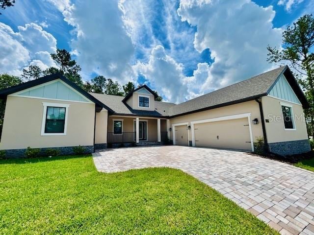 4800 Hickory Oak Dr, Brooksville, FL 34601 - view of front of house featuring decorative driveway, an attached garage, a front yard, and board and batten siding