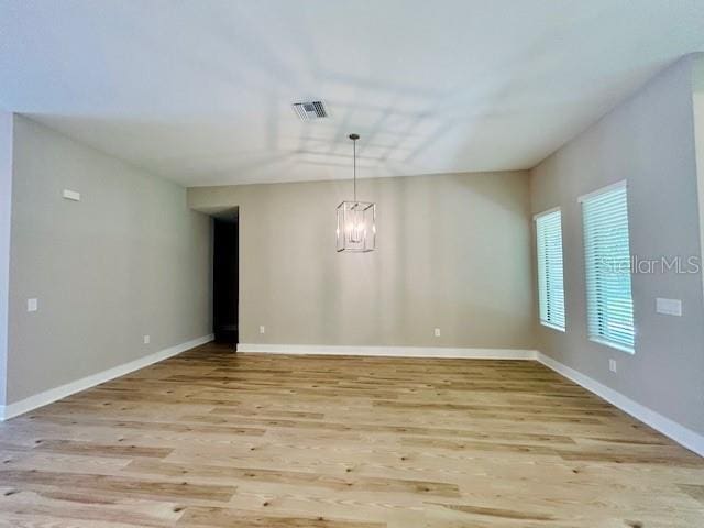4800 Hickory Oak Dr, Brooksville, FL 34601 - unfurnished room featuring wood finished floors and a chandelier