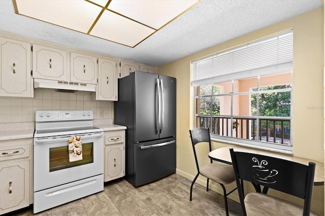840 Virginia St Unit 301, Dunedin, FL 34698 - kitchen with freestanding refrigerator, white electric range oven, under cabinet range hood, light countertops, and a textured ceiling