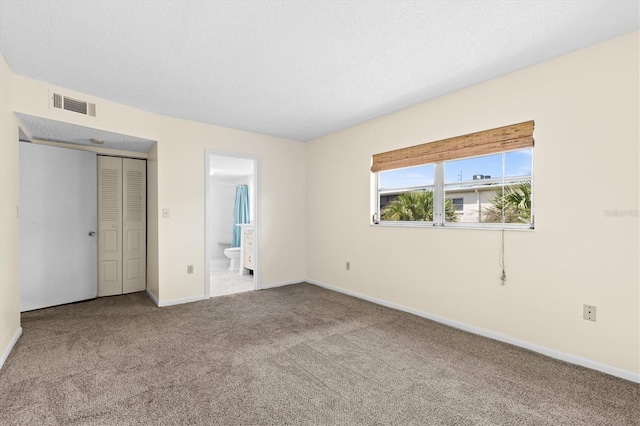 840 Virginia St Unit 301, Dunedin, FL 34698 - unfurnished bedroom featuring carpet, ensuite bath, and a closet