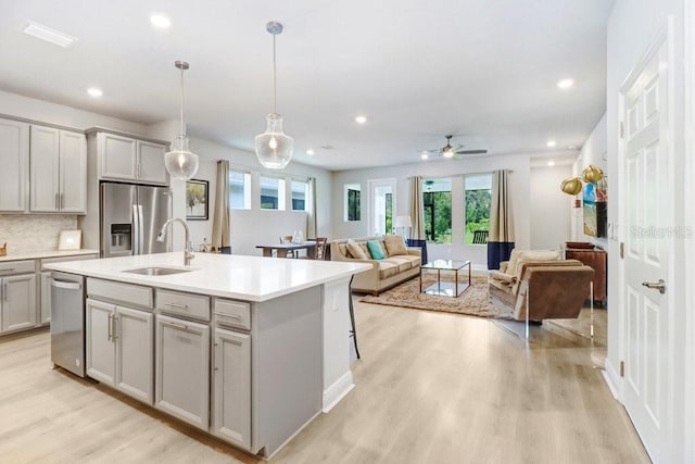 11809 Catawba Cv, Parrish, FL 34219 - kitchen featuring appliances with stainless steel finishes, gray cabinetry, light wood-style floors, healthy amount of natural light, and recessed lighting