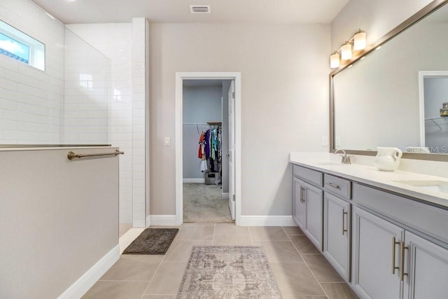 11809 Catawba Cv, Parrish, FL 34219 - bathroom with a walk in closet, double vanity, a walk in shower, and tile patterned flooring