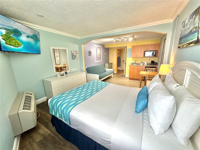 445 S Gulfview Blvd Unit 421, Clearwater Beach, FL 33767 - bedroom featuring arched walkways, ornamental molding, rail lighting, a textured ceiling, and light wood-style floors