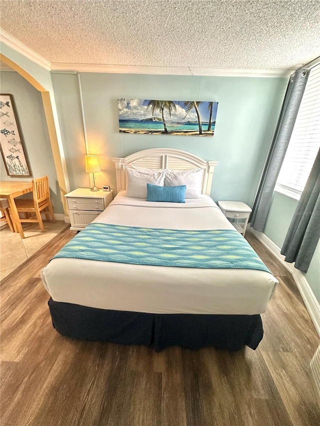 445 S Gulfview Blvd Unit 421, Clearwater Beach, FL 33767 - bedroom featuring a textured ceiling, crown molding, and wood finished floors