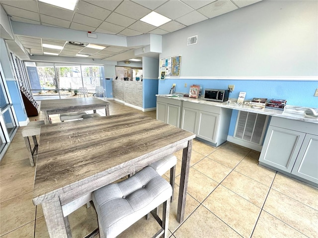 445 S Gulfview Blvd Unit 421, Clearwater Beach, FL 33767 - kitchen featuring a drop ceiling, light countertops, light tile patterned flooring, and gray cabinets