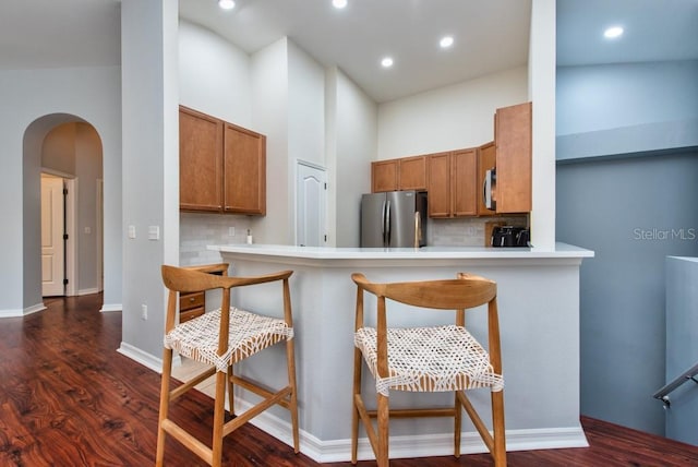 7001 Interbay Blvd Unit 121, Tampa, FL 33616 - kitchen featuring stainless steel appliances, brown cabinets, decorative backsplash, arched walkways, and recessed lighting