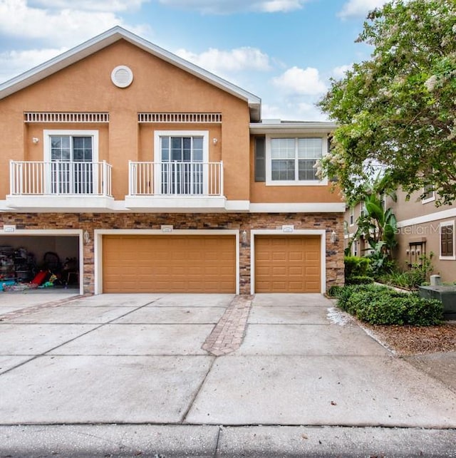 7001 Interbay Blvd Unit 121, Tampa, FL 33616 - townhome / multi-family property featuring a garage, stucco siding, stone siding, and concrete driveway