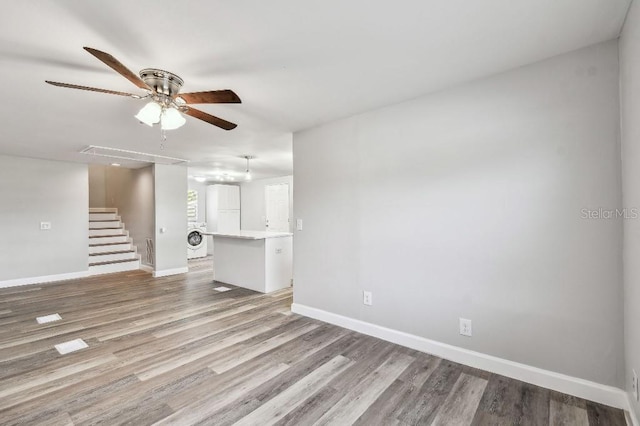 38323 11th Ave, Zephyrhills, FL 33542 - unfurnished living room with washer / dryer, a ceiling fan, stairway, and light wood-style flooring