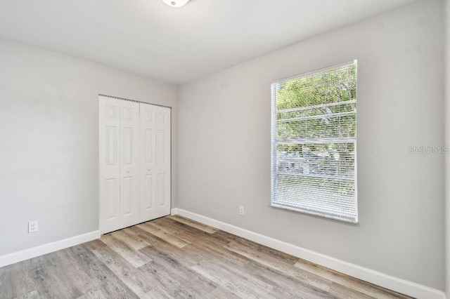 38323 11th Ave, Zephyrhills, FL 33542 - unfurnished bedroom featuring wood finished floors and a closet