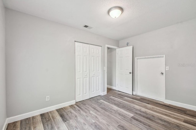 38323 11th Ave, Zephyrhills, FL 33542 - unfurnished bedroom with a closet, wood finished floors, and a textured ceiling