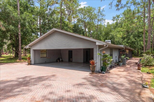 935 Ranch Rd, Tarpon Springs, FL 34688 - view of home's exterior featuring decorative driveway and a chimney