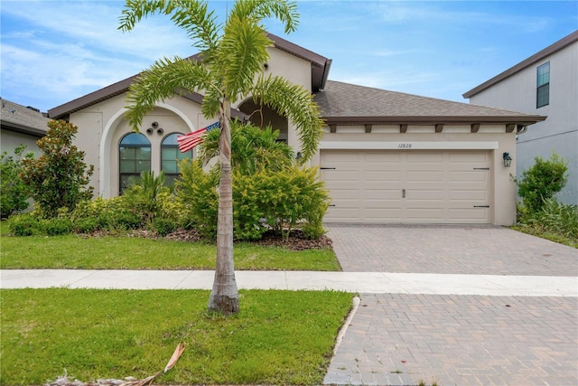 12828 Satin Lily Dr, Riverview, FL 33579 - view of front facade with decorative driveway, stucco siding, a garage, and a front yard