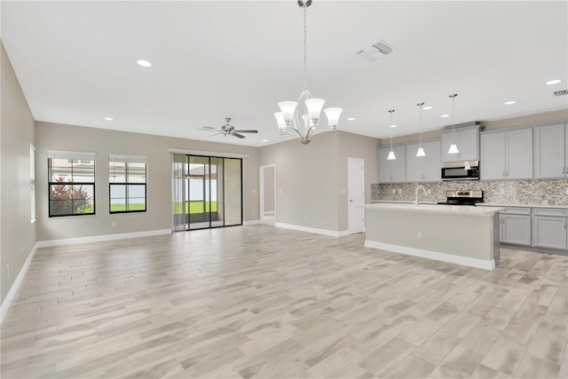 12828 Satin Lily Dr, Riverview, FL 33579 - kitchen featuring stainless steel appliances, open floor plan, backsplash, light countertops, and recessed lighting