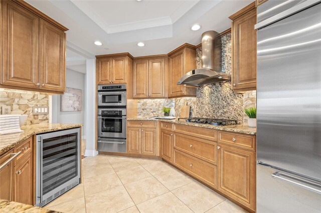400 Beach Dr NE Unit 2301, Saint Petersburg, FL 33701 - kitchen featuring stainless steel appliances, beverage cooler, wall chimney exhaust hood, a tray ceiling, and recessed lighting