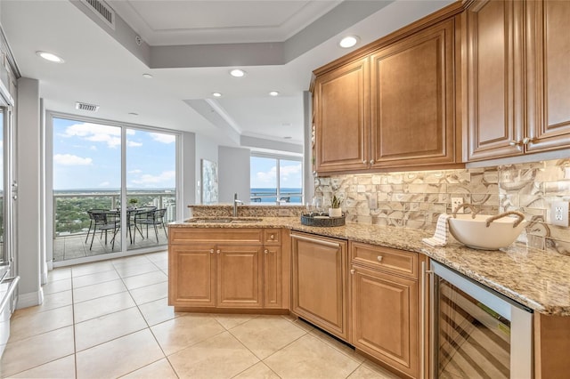 400 Beach Dr NE Unit 2301, Saint Petersburg, FL 33701 - kitchen featuring a tray ceiling, wine cooler, light stone countertops, tasteful backsplash, and a peninsula