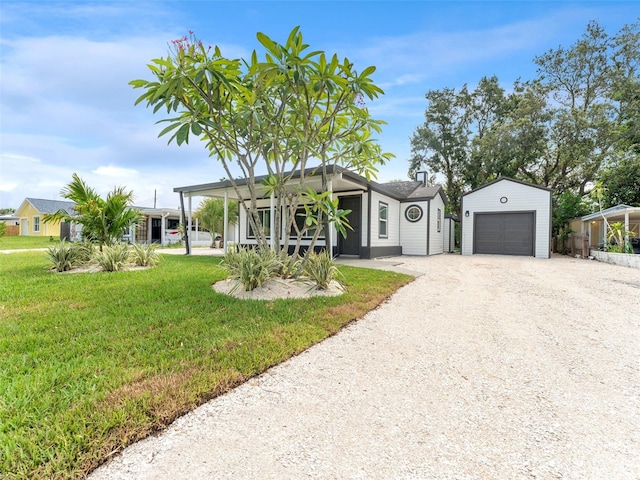 960 65th St S, Saint Petersburg, FL 33707 - view of front of home with a front yard, an outbuilding, dirt driveway, and a garage