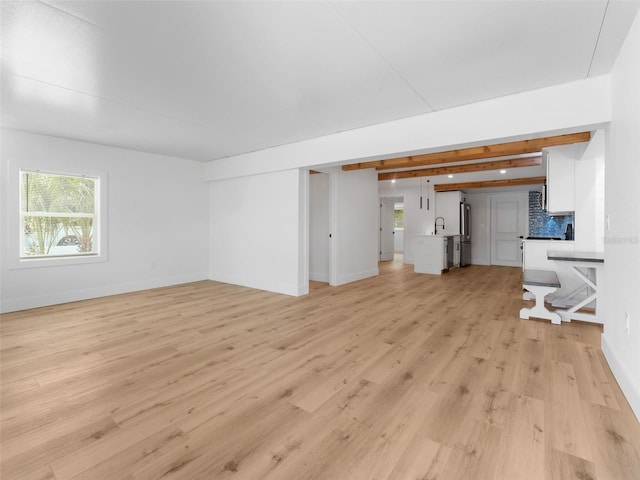 960 65th St S, Saint Petersburg, FL 33707 - unfurnished living room with light wood finished floors and plenty of natural light