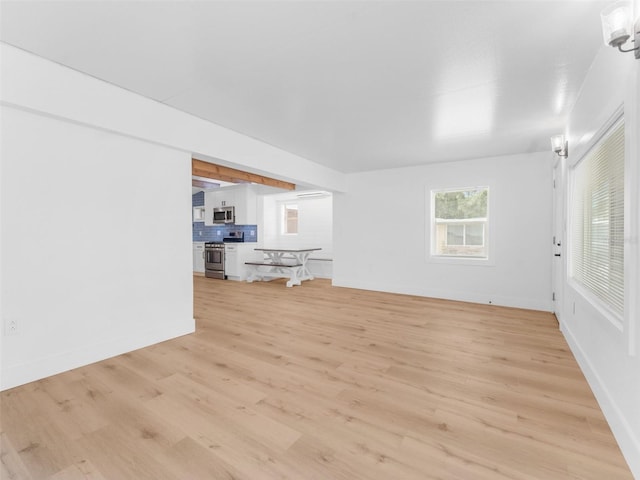 960 65th St S, Saint Petersburg, FL 33707 - unfurnished living room featuring light wood-style floors and baseboards