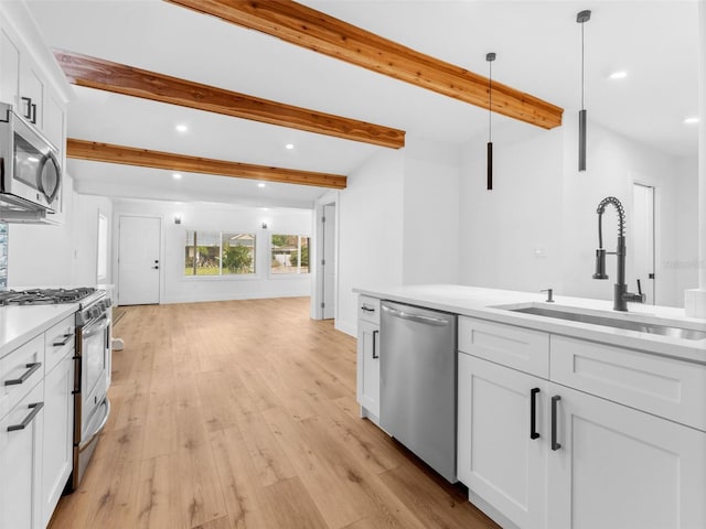 960 65th St S, Saint Petersburg, FL 33707 - kitchen with appliances with stainless steel finishes, recessed lighting, light countertops, beam ceiling, and light wood-style floors
