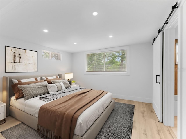 960 65th St S, Saint Petersburg, FL 33707 - bedroom featuring a barn door, light wood-style floors, multiple windows, and recessed lighting