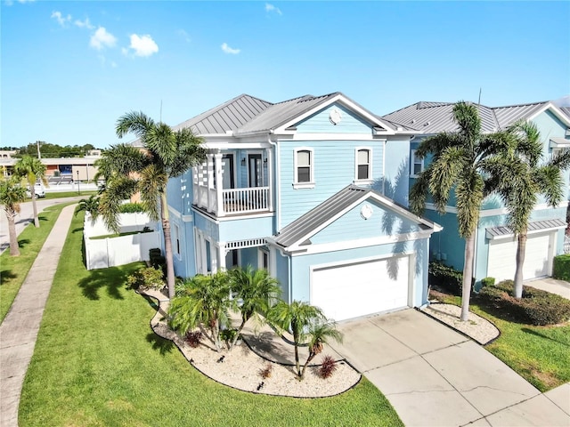 6545 Simone Shores Cir, Apollo Beach, FL 33572 - view of front of property featuring a balcony, driveway, a front lawn, a metal roof, and a standing seam roof