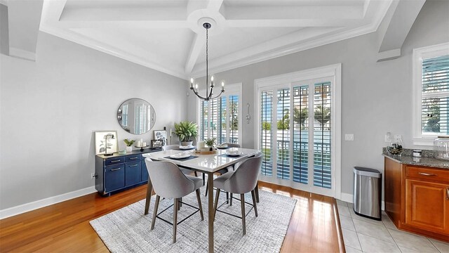 6545 Simone Shores Cir, Apollo Beach, FL 33572 - dining space with light wood-style floors, a chandelier, and lofted ceiling