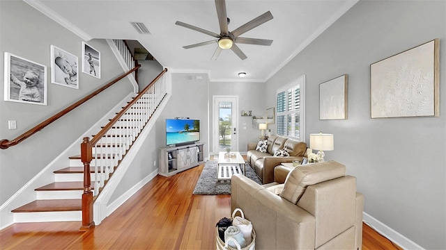 6545 Simone Shores Cir, Apollo Beach, FL 33572 - living room with light wood-type flooring, stairway, a ceiling fan, ornamental molding, and vaulted ceiling