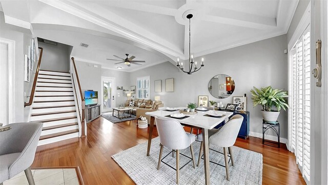6545 Simone Shores Cir, Apollo Beach, FL 33572 - dining area with a ceiling fan, stairway, wood finished floors, crown molding, and a chandelier