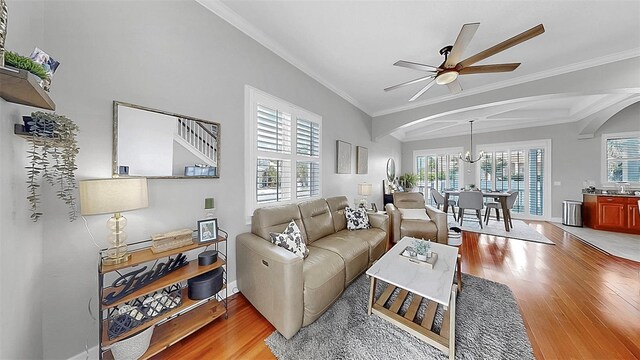 6545 Simone Shores Cir, Apollo Beach, FL 33572 - living area featuring ceiling fan, light wood-style floors, arched walkways, a chandelier, and ornamental molding
