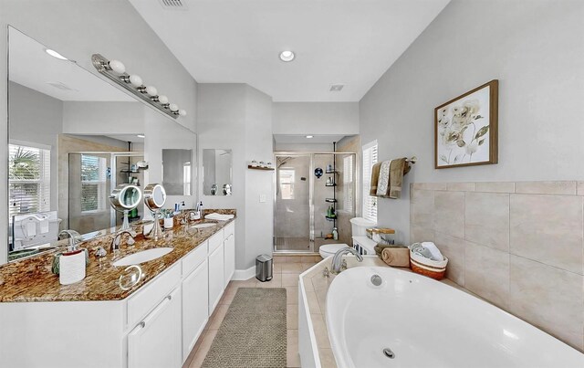 6545 Simone Shores Cir, Apollo Beach, FL 33572 - bathroom featuring double vanity, plenty of natural light, a garden tub, and a stall shower