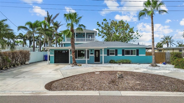 7950 Causeway Blvd N, Saint Petersburg, FL 33707 - view of front of house with curved driveway, a balcony, stucco siding, a garage, and a shingled roof