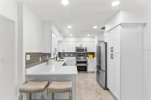 7950 Causeway Blvd N, Saint Petersburg, FL 33707 - kitchen with appliances with stainless steel finishes, backsplash, white cabinets, light countertops, and recessed lighting
