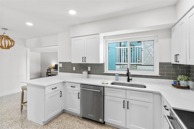 7950 Causeway Blvd N, Saint Petersburg, FL 33707 - kitchen featuring stainless steel dishwasher, a peninsula, white cabinets, stove, and backsplash