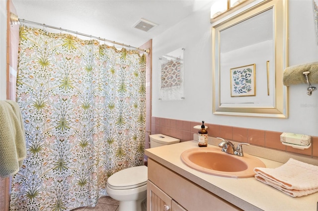 7950 Causeway Blvd N, Saint Petersburg, FL 33707 - bathroom featuring vanity, tile walls, a shower with shower curtain, a wainscoted wall, and tile patterned floors