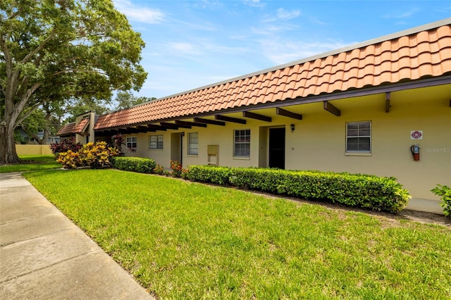 1701 Pinehurst Rd Unit 18D, Dunedin, FL 34698 - view of side of property with a tile roof, a yard, and stucco siding