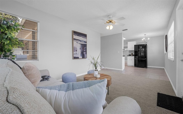 2614 W Idlewild Ave, Tampa, FL 33614 - living room with ceiling fan, light colored carpet, light tile patterned flooring, a textured ceiling, and a chandelier