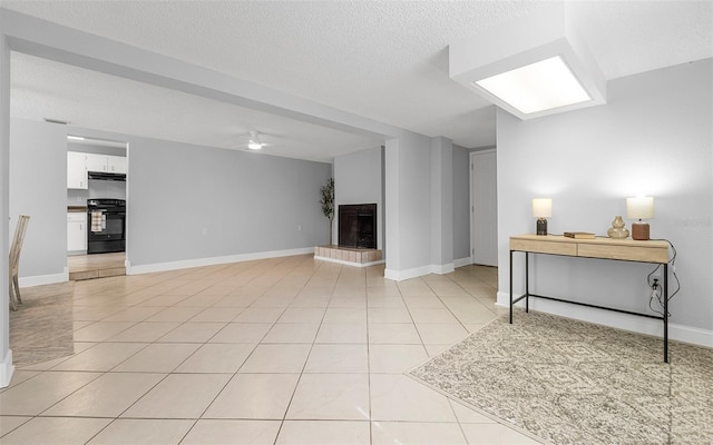 2614 W Idlewild Ave, Tampa, FL 33614 - below grade area featuring light tile patterned floors, a textured ceiling, a fireplace with raised hearth, and a ceiling fan