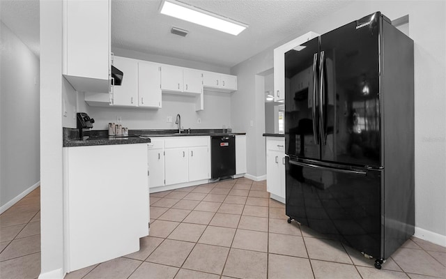 2614 W Idlewild Ave, Tampa, FL 33614 - kitchen with black appliances, dark countertops, light tile patterned floors, white cabinets, and a textured ceiling